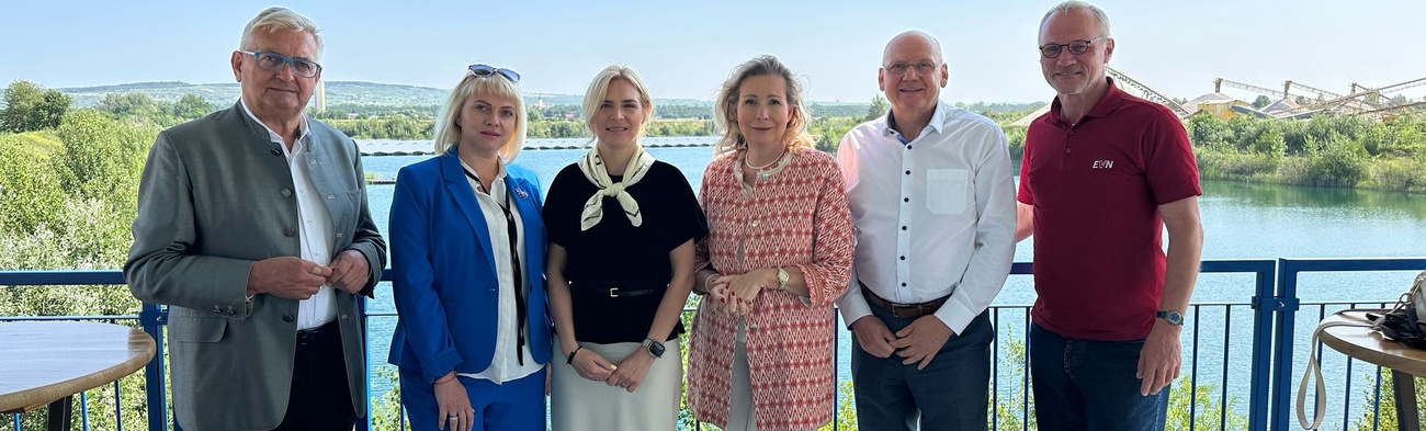 Auf diesem Gruppenfoto sind zu sehen, von links beginnend: Bürgermeister Alfred Riedl, eine Dolmetscherin, Hanna Zamazeeva, Leiterin der ukrainischen Energieagentur, IV-NÖ-Geschäftsführerin Michaela Roither, Helwig Überacker, bei der EVN zuständig für Windkraft-, PV- und Wasserkraftprojekte, und EVN-Kommunikationschef Stefan Zach. Die Aufnahme wurde  vor dem Hintergrund der Floating-Photovoltaikanlage in Grafenwörth gemacht.