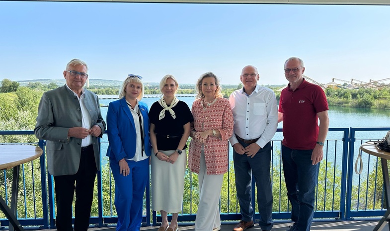 Auf diesem Gruppenfoto sind zu sehen, von links beginnend: Bürgermeister Alfred Riedl, eine Dolmetscherin, Hanna Zamazeeva, Leiterin der ukrainischen Energieagentur, IV-NÖ-Geschäftsführerin Michaela Roither, Helwig Überacker, bei der EVN zuständig für Windkraft-, PV- und Wasserkraftprojekte, und EVN-Kommunikationschef Stefan Zach. Die Aufnahme wurde  vor dem Hintergrund der Floating-Photovoltaikanlage in Grafenwörth gemacht.