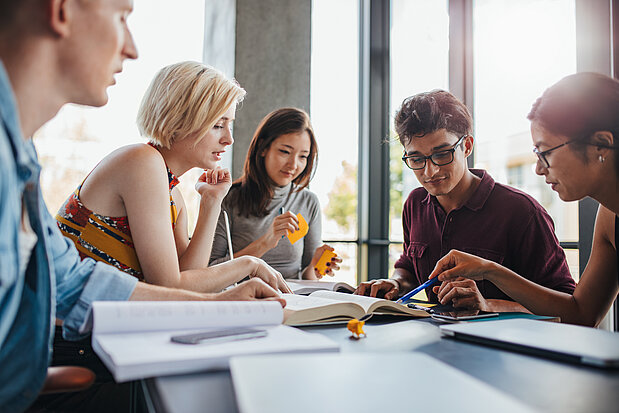 Diverse Gruppe von Studenten lernen in einer Bibliothek