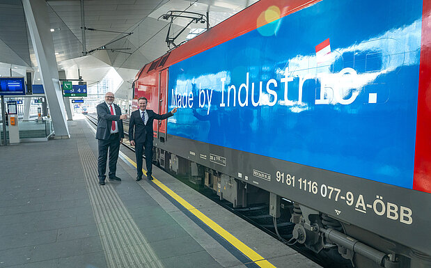 Eine ÖBB-Lok mit dem Schriftzug "Made by Industrie", davor stehen ÖBB CEO Andreas Matthä und IV-Präsident Georg Knill