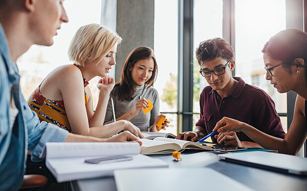 Diverse Gruppe von Studenten lernen in einer Bibliothek